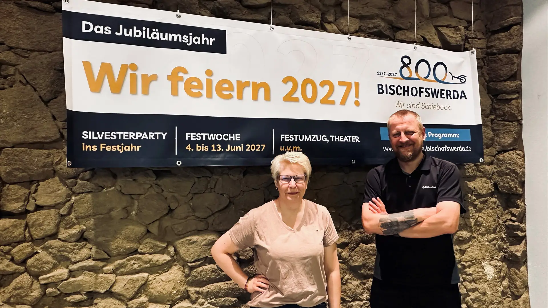 Jana Kalauch und Sascha Hache vor einem Banner zum 800-jährigen Jubiläum von Bischofswerda